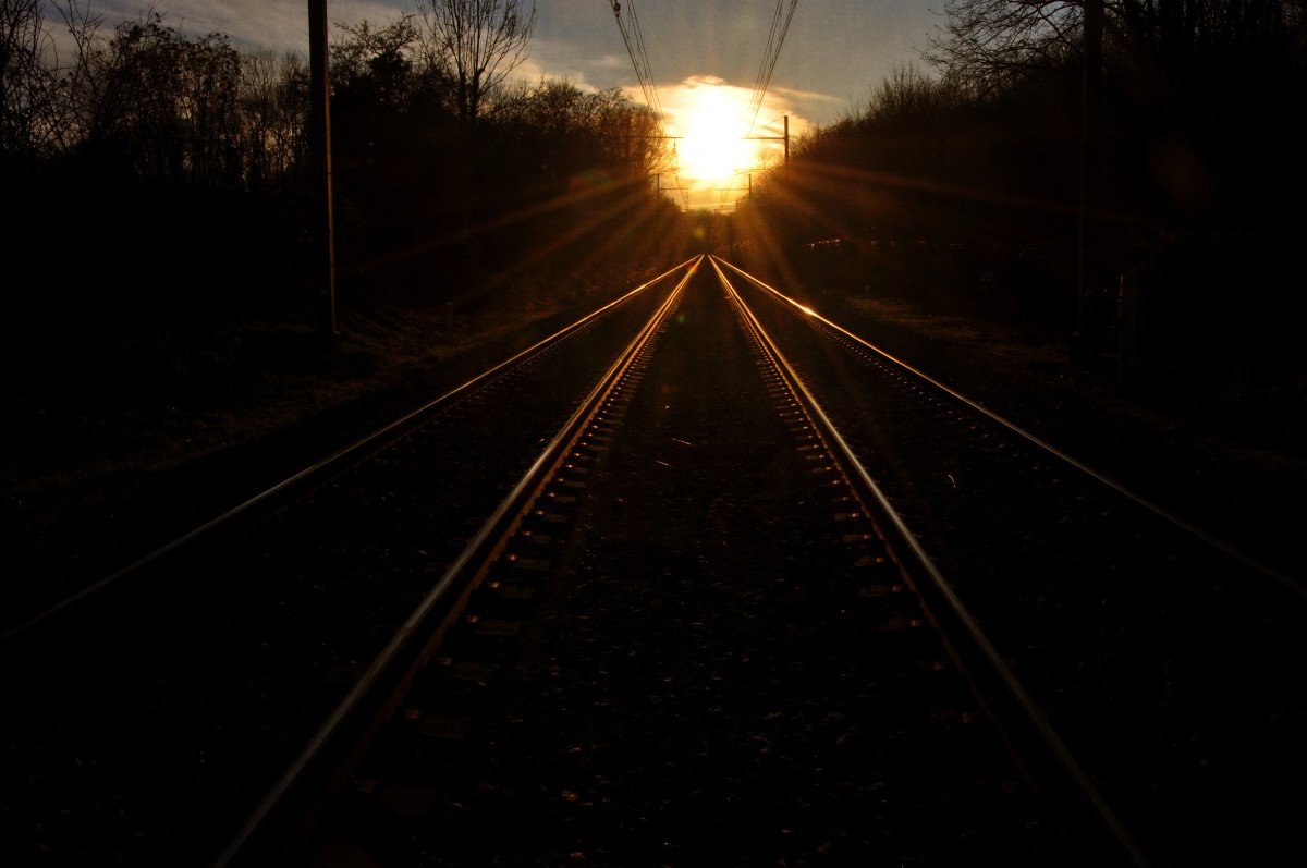 Soleil couchant sur une voie ferrée
