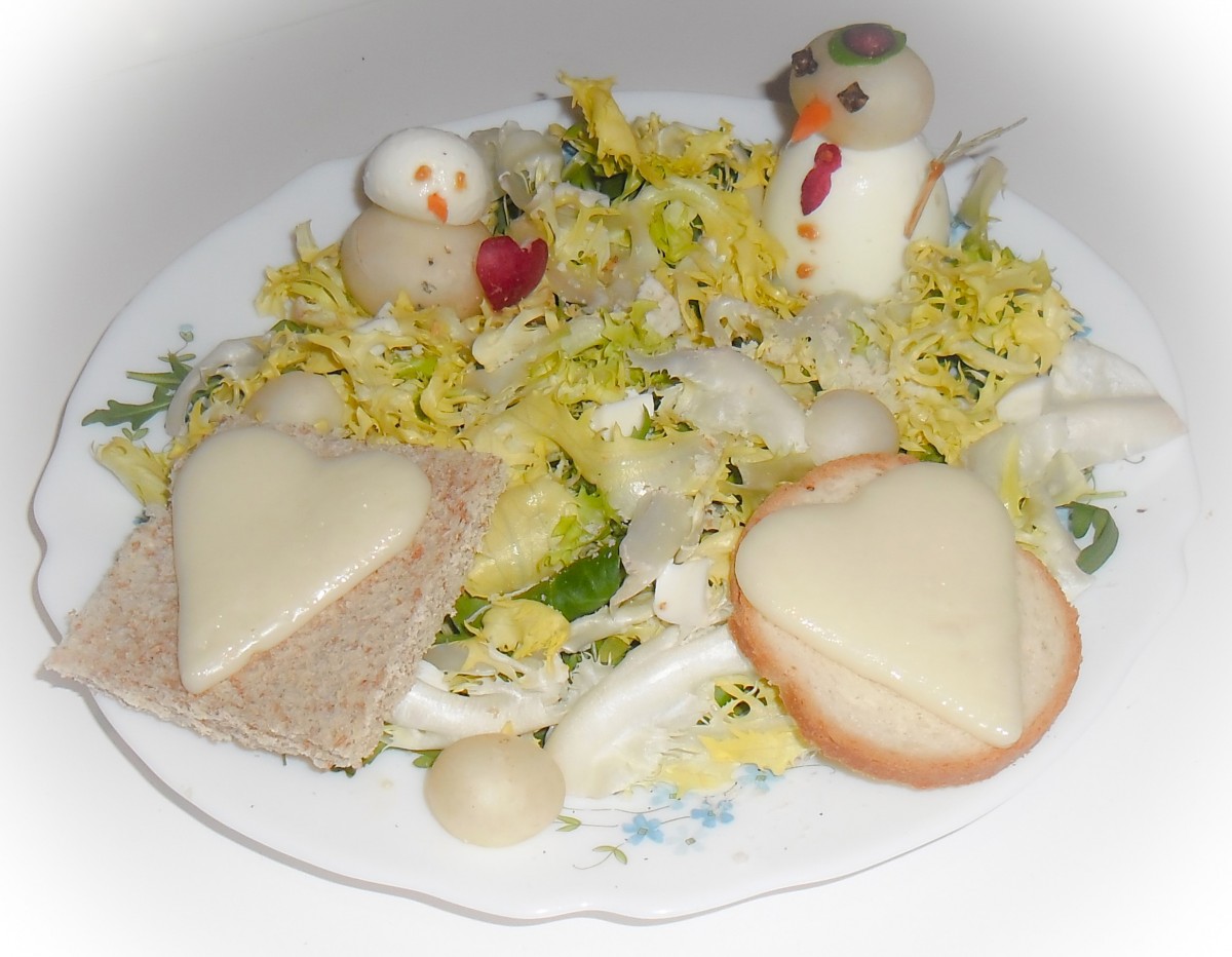 Salade frisée en banquise avec des bonhommes de neige en oeuf et mozzarella et des toast de fromage en coeur