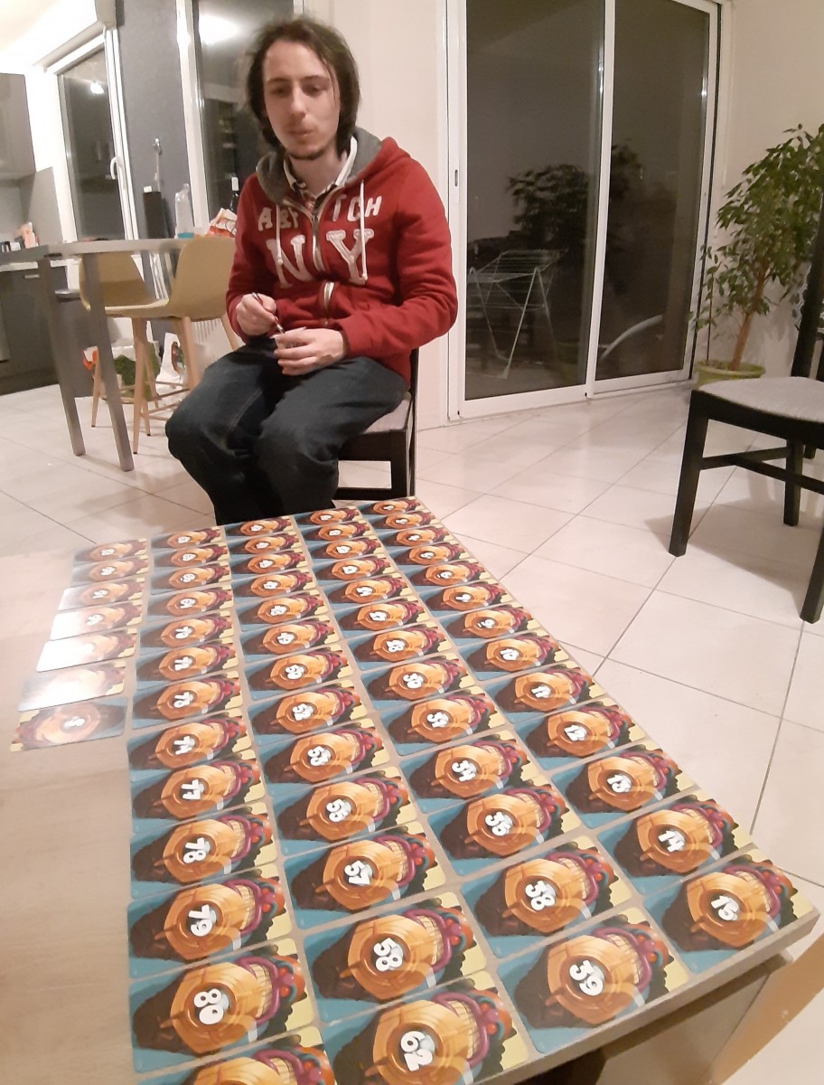Florian devant une table pleine de cartes du jeu Unlock