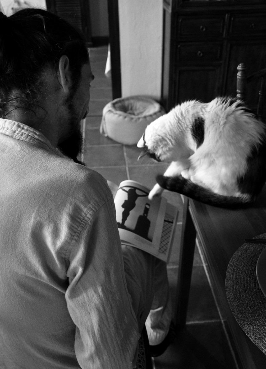Homme lisant de dos avec un chat - noir et blanc