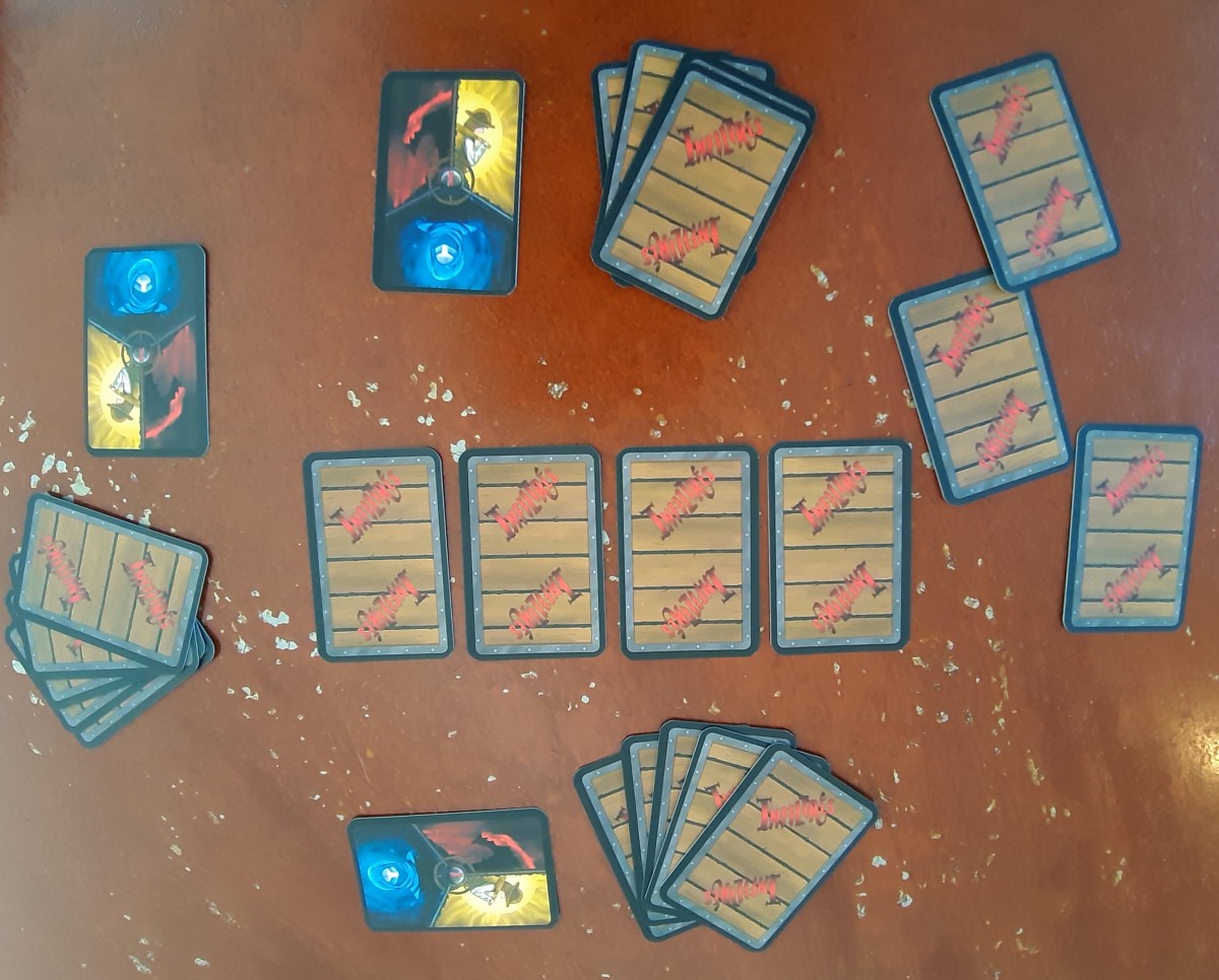 3 cartes Rôles Infiltrés avec une main et 6 cartes au centre dont une en train d'être échangée