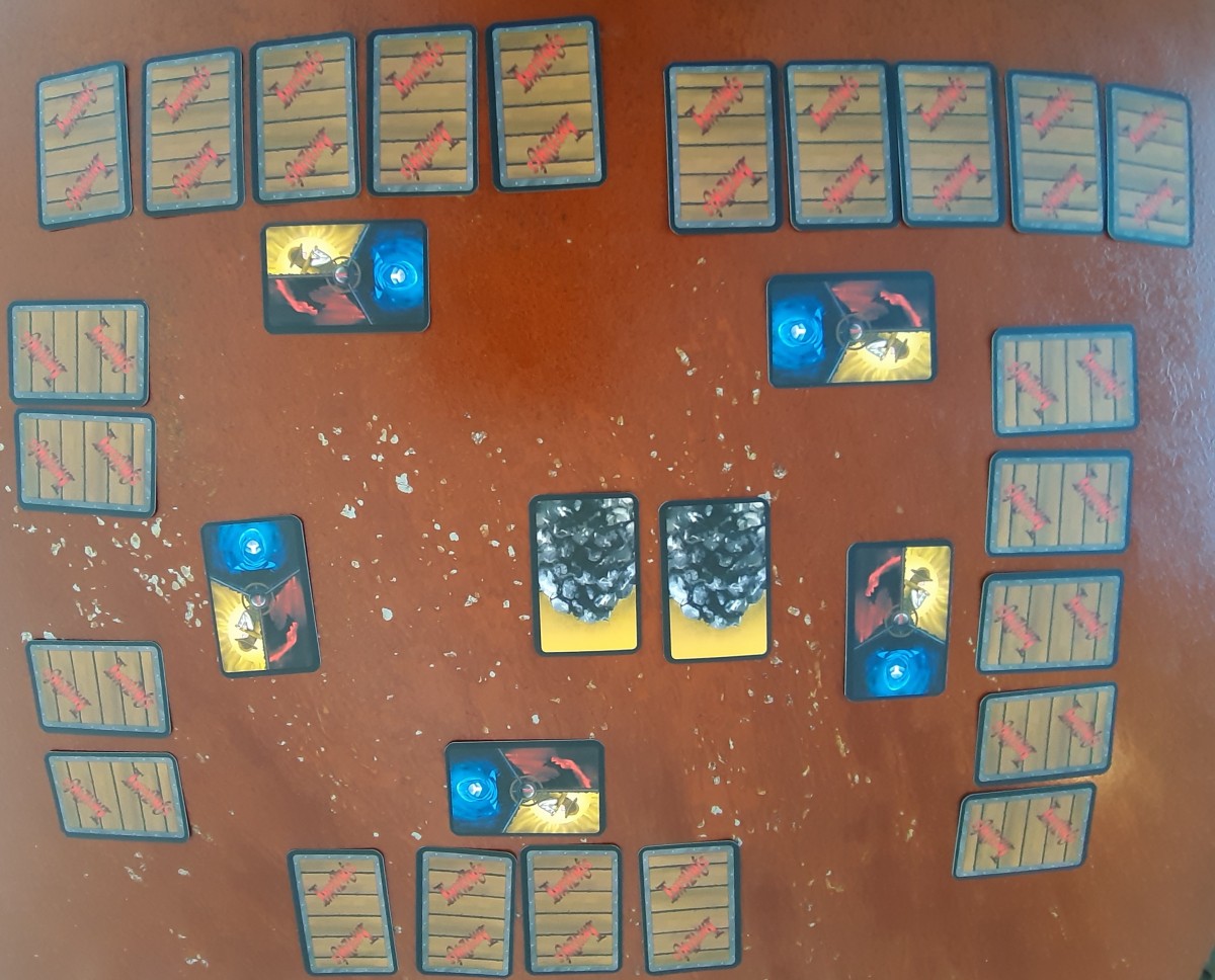 5 cartes Rôles face cachée et 5 mains de 5 cartes face cachée 2 cartes Charbon au centre face visible
