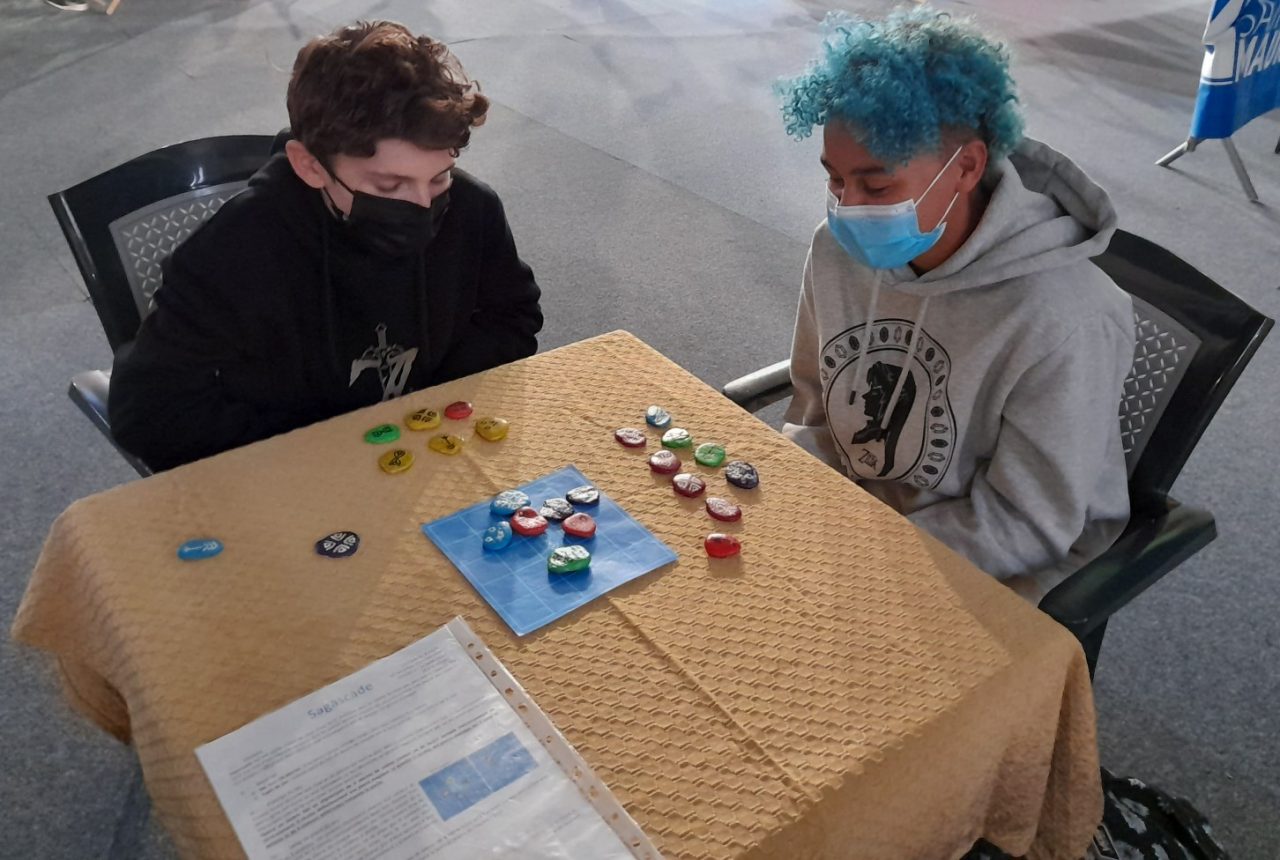 2 personnes assises à une table jouant au jeu Sagascade du Projet CarTylion