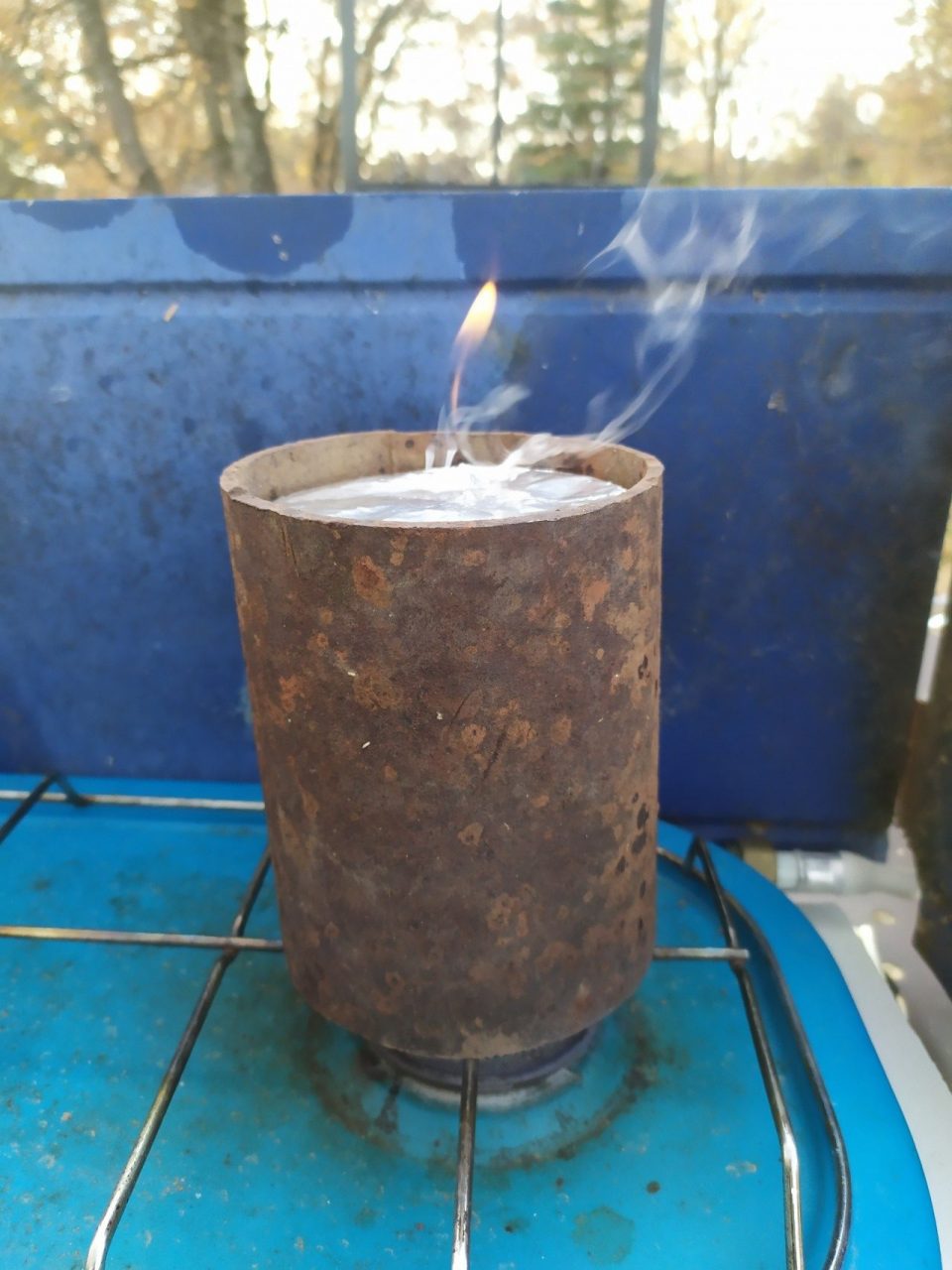 Boîte de conserve sur le feu ayant un tube métallique pour la protéger du froid pendant la pyrolyse du fusain
