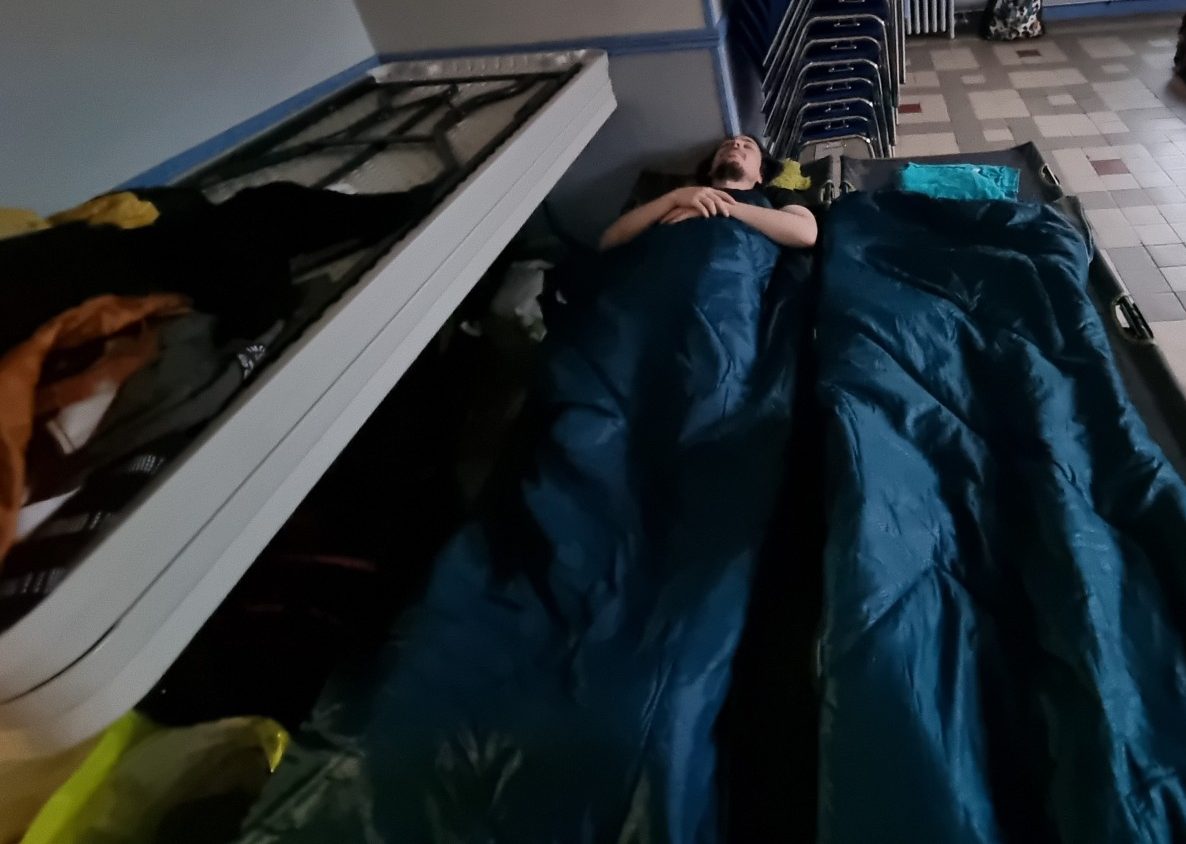 Florian sur un lit de camp dans son duvet bleu et son oreiller Moutonouille