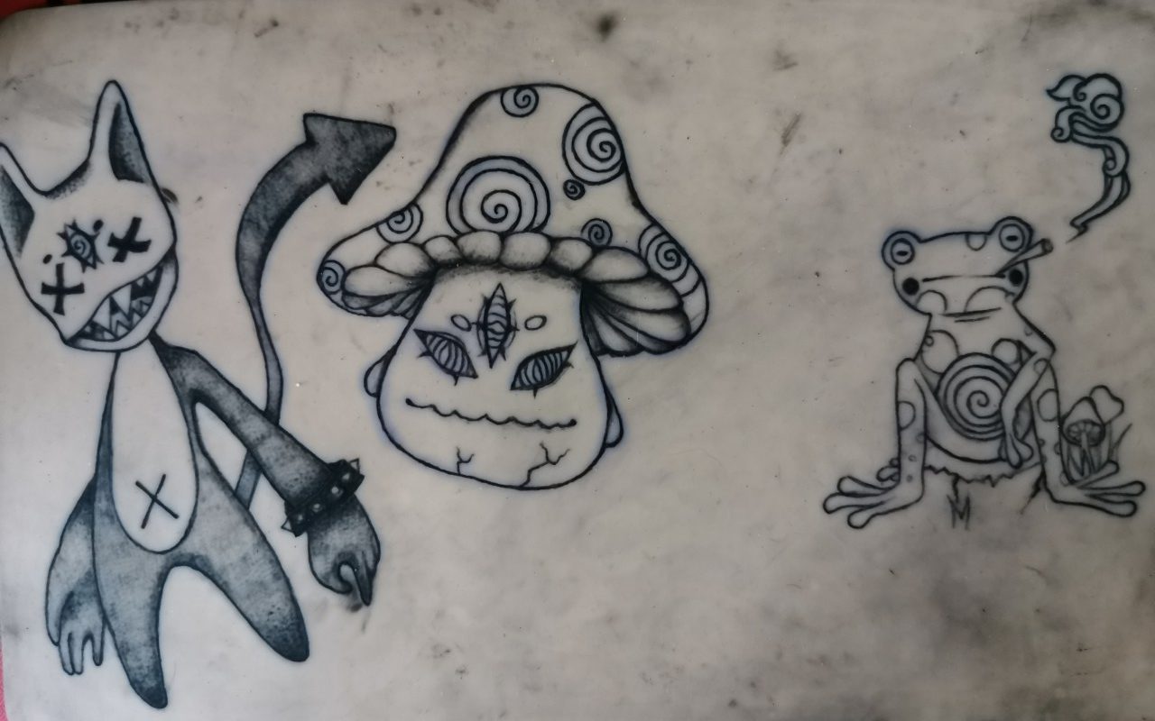 Un Pokémon chat, un champignon et une grenouille qui fume en tatouages sur une peau synthétique