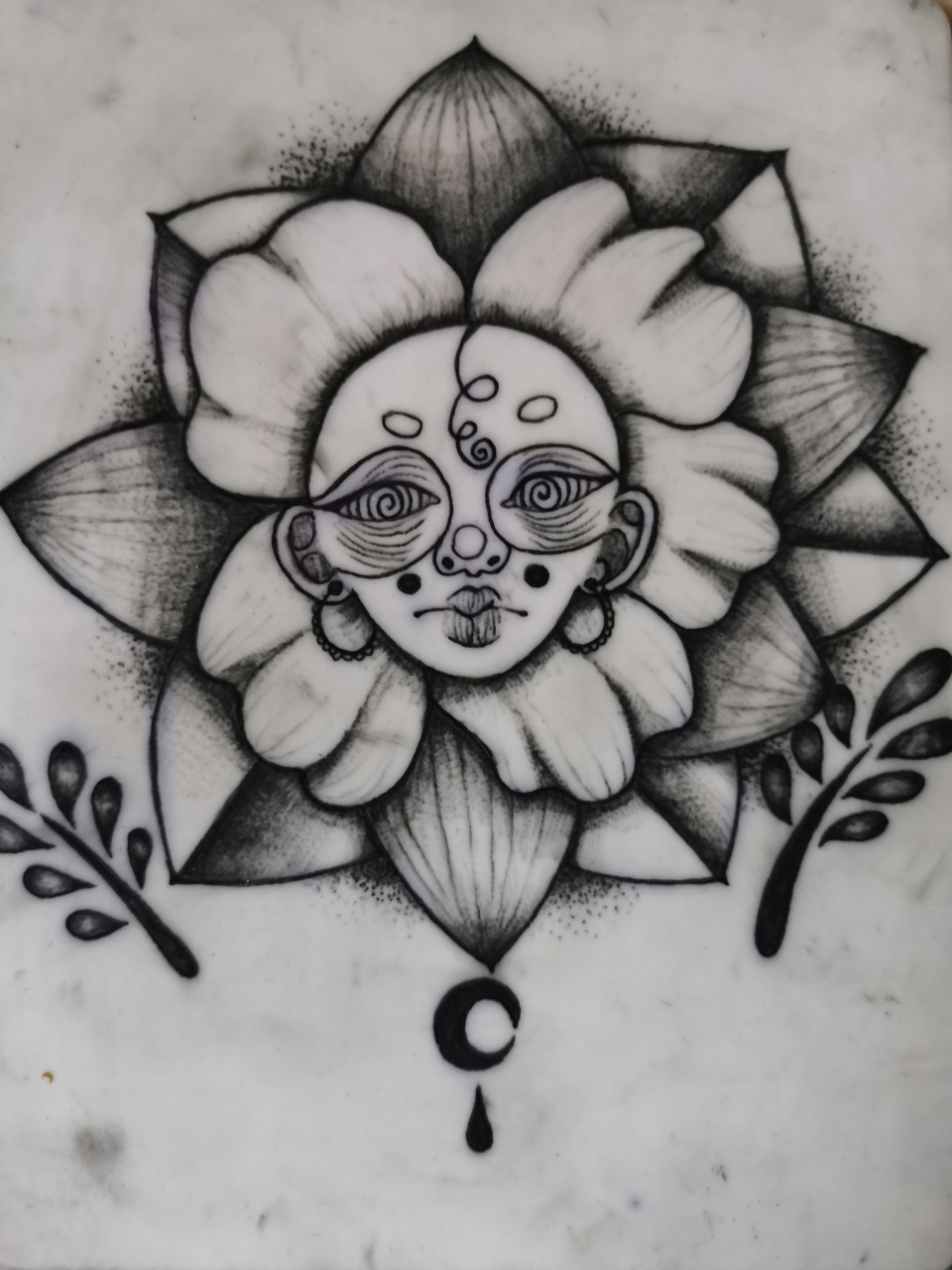 Tatouage de fleur avec un visage de femme avec des boucles d'oreilles créoles sur peau synthétique