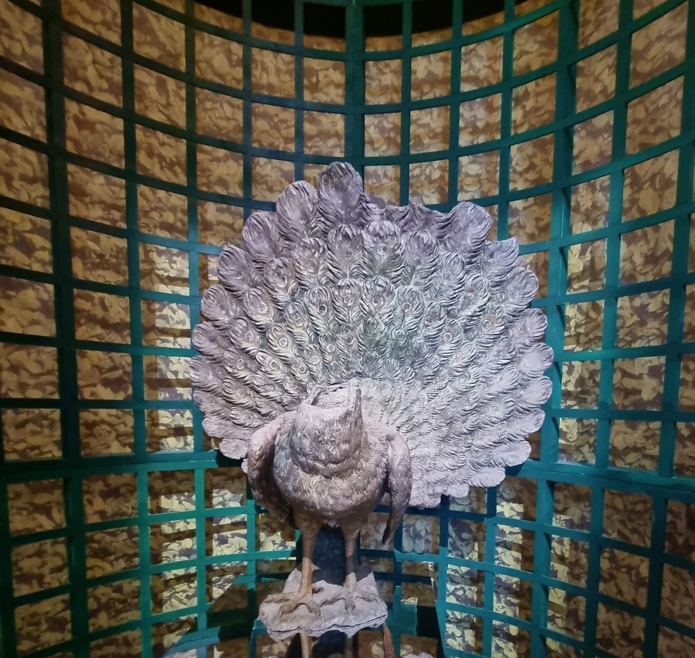 Statue de paon en plomb dans le labyrinthe de l'exposition Les animaux du Roi