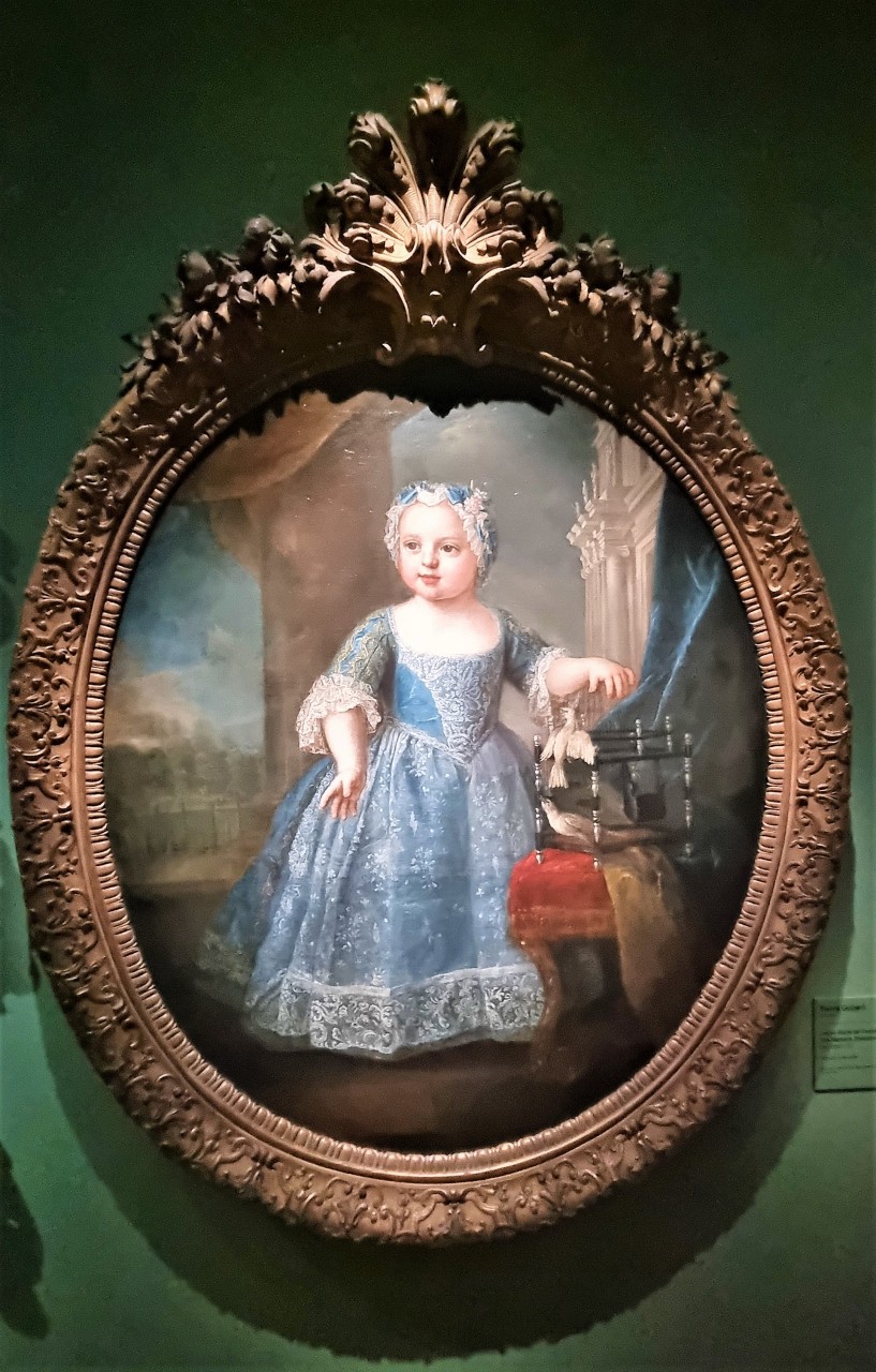 Tableau au format médaillon d'une fillette en robe bleue avec un petit oiseau blanc