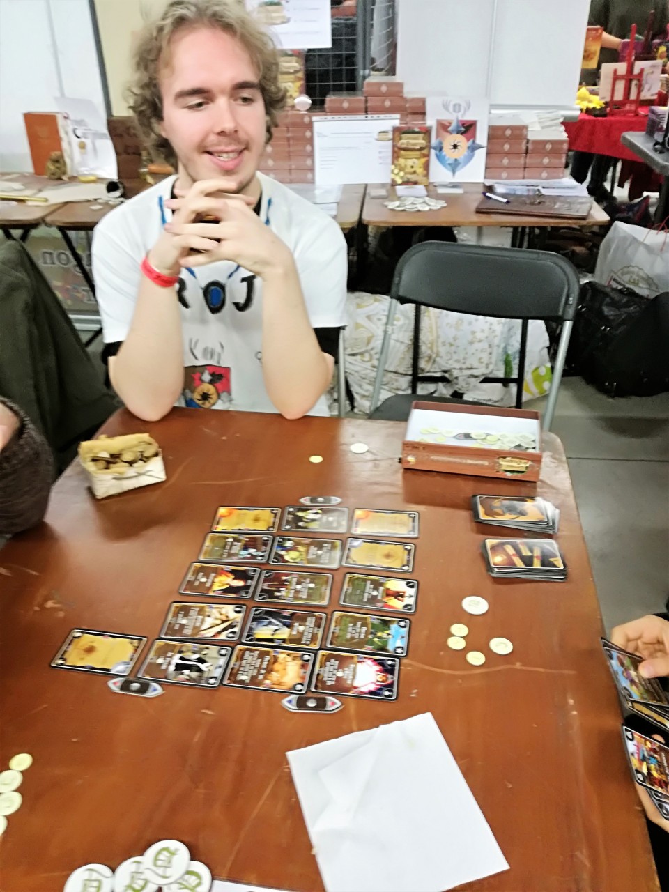Vincent (VJO) à une table avec le jeu Conseil de Guerre sur la table et deux joueurs.
