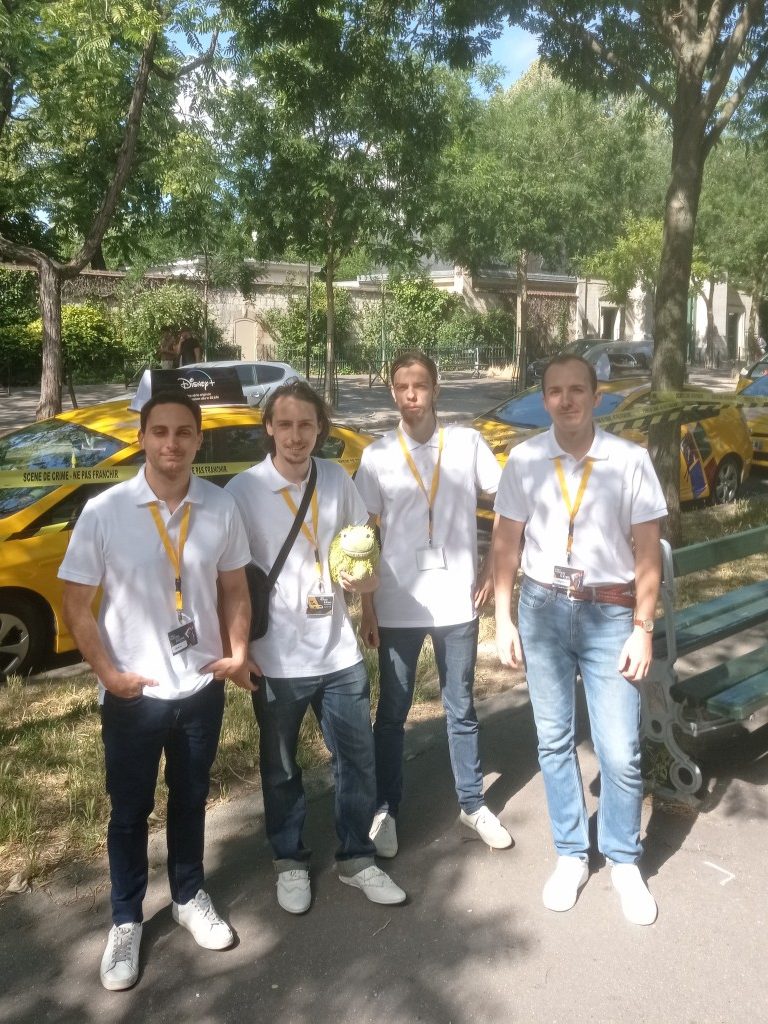 4 personnes debout devant des taxis jaunes