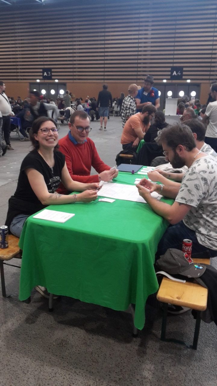 Joueurs souriants assis à une table avec une nappe verte